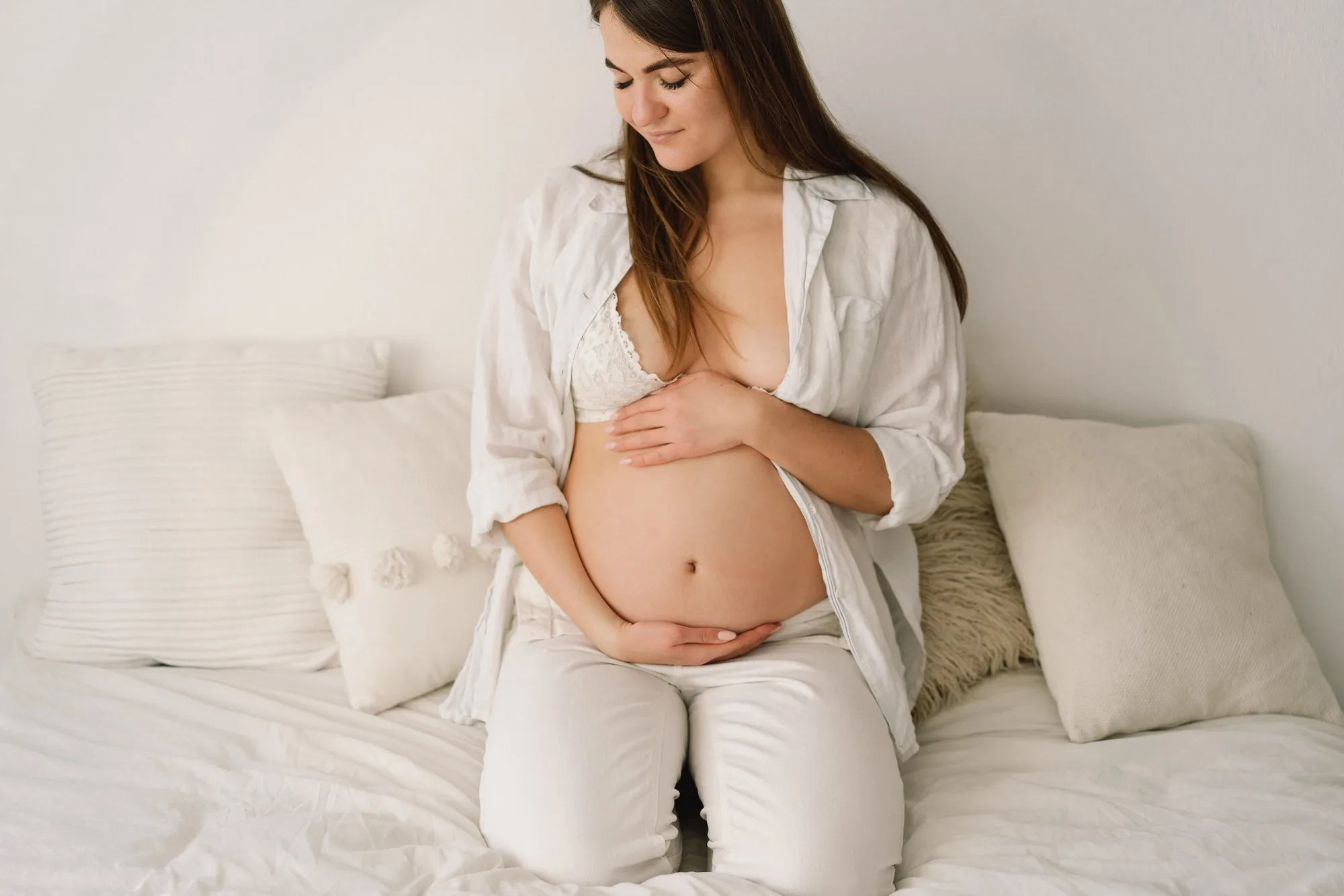 A beautiful pregnant woman, dressed in white clothes