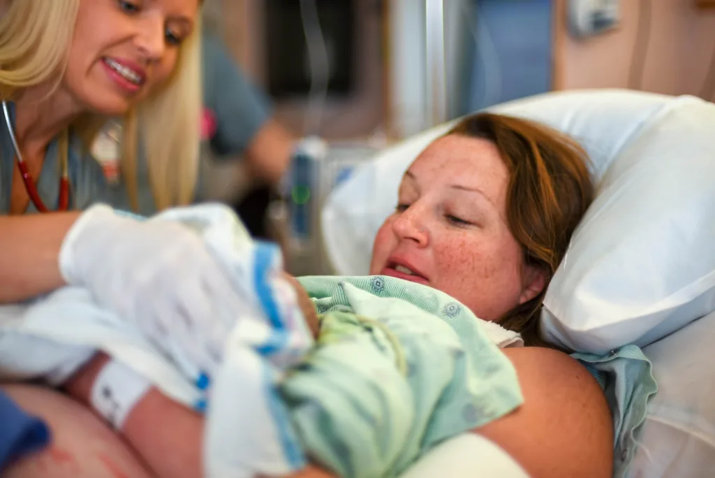Junge Frau im Krankenhaus bei der Geburt